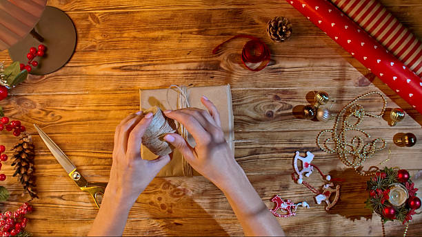 istock Cutting twine for wrapping a Christmas gift on a wooden table 2245222432