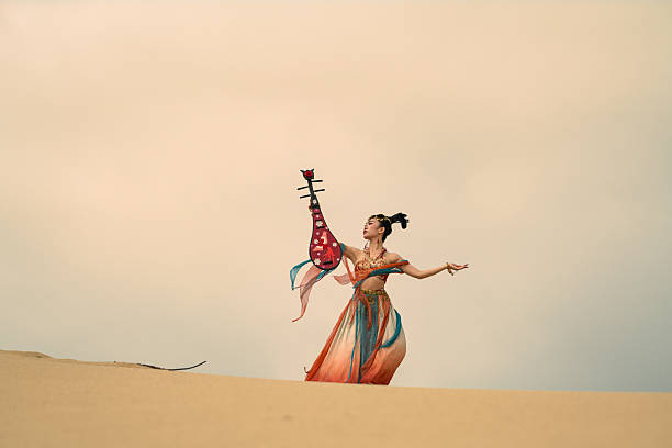Actress wearing period Dunhuang costumes, striking a pose on the Nam Cuong sand dunes, Ninh Thuan province, central Vietnam