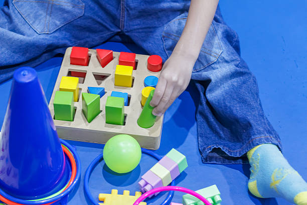Child Playing with Colorful Shape Blocks for Early Learning