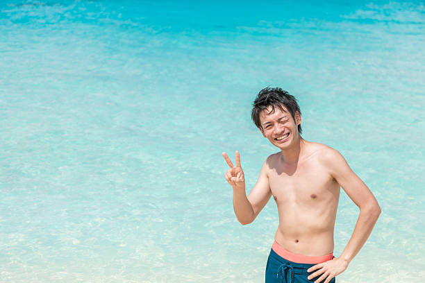 istock Asian man having fun on the beach at a resort 2245240574