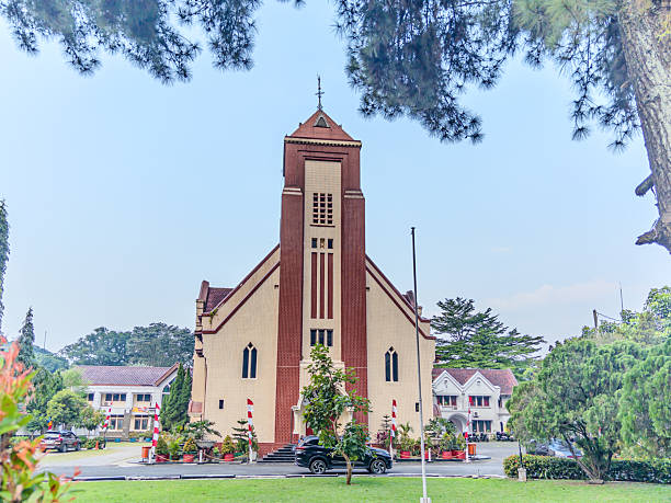 istock historical GPIB Zebaoth Church in Bogor, a striking example of classic architecture, surrounded by a lush green lawn and tropical trees. 2245246172