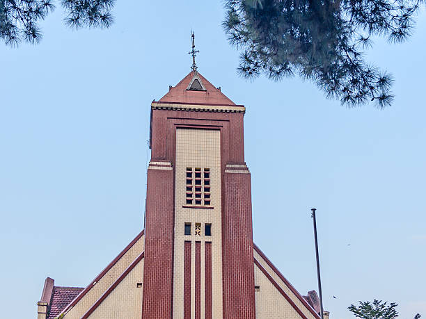 istock historical GPIB Zebaoth Church in Bogor, a striking example of classic architecture, surrounded by a lush green lawn and tropical trees. 2245250770