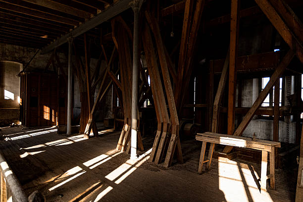 istock Abandoned industrial space with wooden beams and sunlight streaming through windows 2245251124