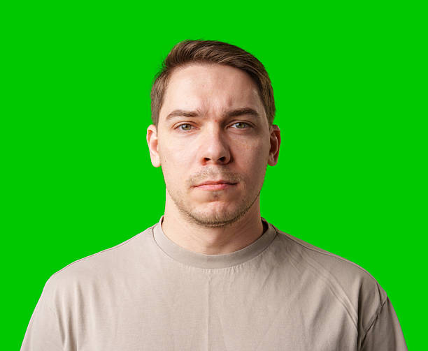 istock A man standing against a vibrant green backdrop with neutral expression 2245256341