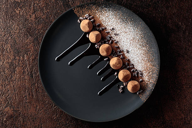 istock Chocolate truffles on a black plate with chocolate sauce. 2245256433