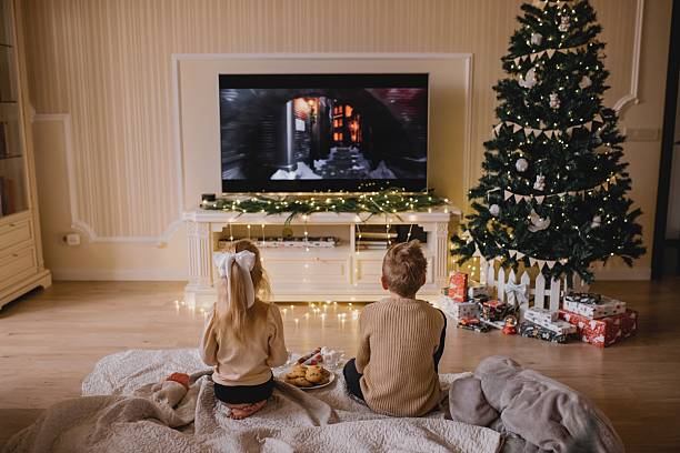 istock Children Watching Christmas Movie By Decorated Tree 2245257641