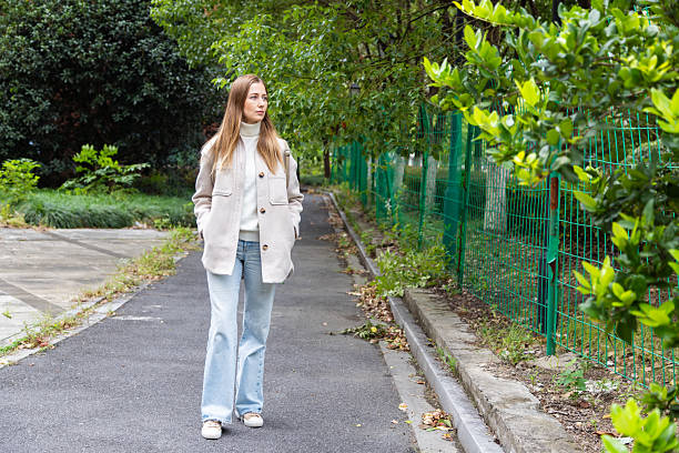 istock Young woman walking along a pathway in a park surrounded by greenery 2245261338