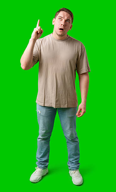 istock Enthusiastic man pointing upwards against a vibrant green background 2245263774