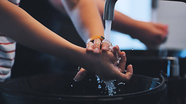 istock Children washing hands thoroughly, practicing good hygiene at bathroom sink with running water and antibacterial soap 2245264134