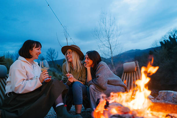 istock Female friends relaxing by the campfire and drinking wine 2245264217