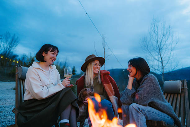 istock Female friends relaxing by the campfire and drinking wine 2245264218