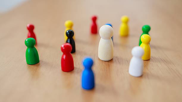istock Leadership concept with recruitment strategy shown by white figure surrounded by game pieces wooden surface inspiring teamwork 2245264259