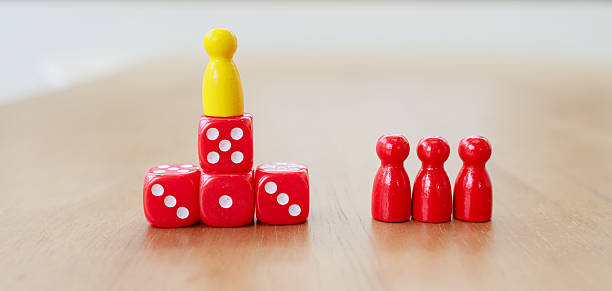 Leadership recruitment concept illustrated by yellow figure standing on red dice symbolizing success and guidance in strategic game setting