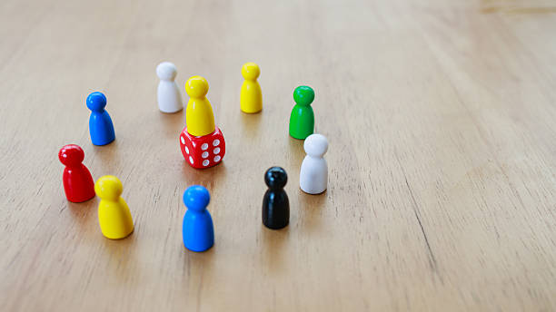 Leadership recruitment concept with game pieces arranged in circle around central figure on dice symbolizing team dynamics and strategy