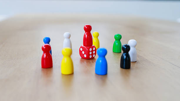 istock Leadership recruitment concept with game pieces arranged in circle around red figure on dice symbolizing authority and teamwork 2245264288