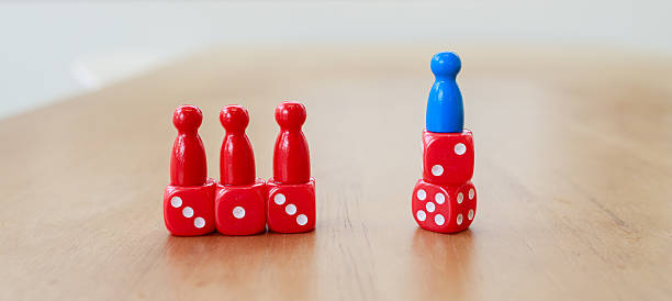 istock Leadership recruitment concept with red and blue game pieces on dice symbolizing team and individual strategy on wooden surface 2245264298
