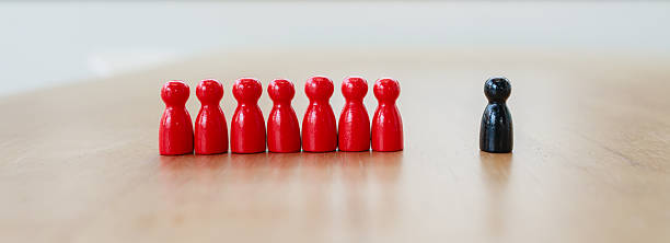 istock Leadership recruitment concept with single black figure separated from group of red figures symbolizing team dynamics and decision making 2245264306