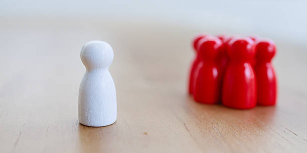 istock Leadership recruitment concept with single white figure standing apart from group of red figures wooden surface inspiring focus and determination 2245264321