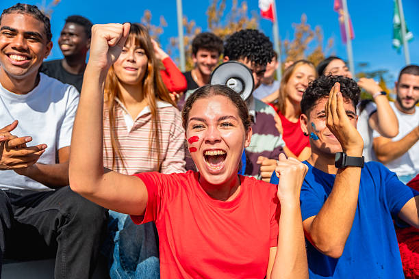 istock Diverse young adults celebrating victory at a stadium 2245267011