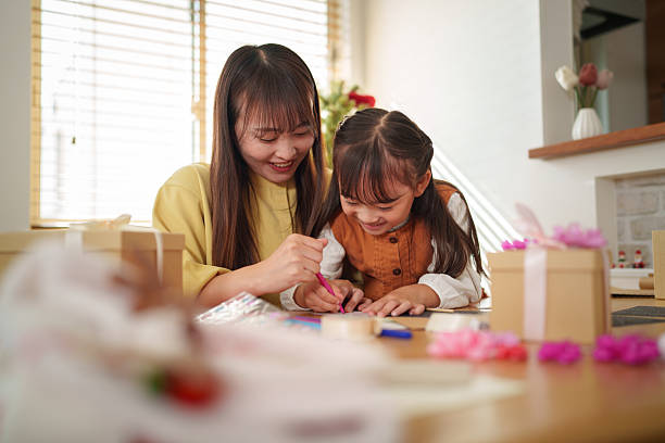 istock Mother Helping Daughter Write a Holiday Card 2245268070