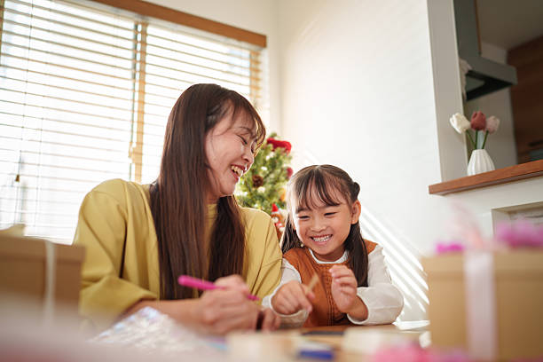 istock Mother Helping Daughter Write a Holiday Card 2245268083
