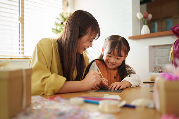 istock Mother Helping Daughter Write a Holiday Card 2245268157