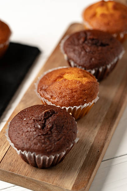 Delightful assortment of chocolate and vanilla muffins on a wooden serving board