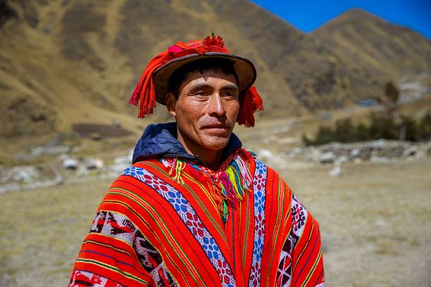 Cusco, Peru – July 04, 2020: Quechua indigenous man in traditional attire in a mountainous landscape, showcasing vibrant cultural clothing.