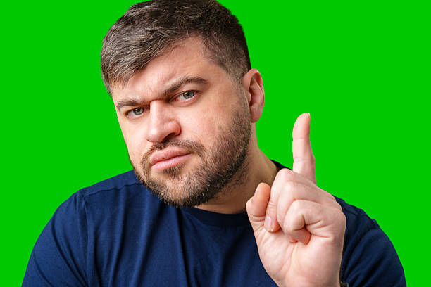 istock A man thoughtfully ponders on a bright green background 2245272719