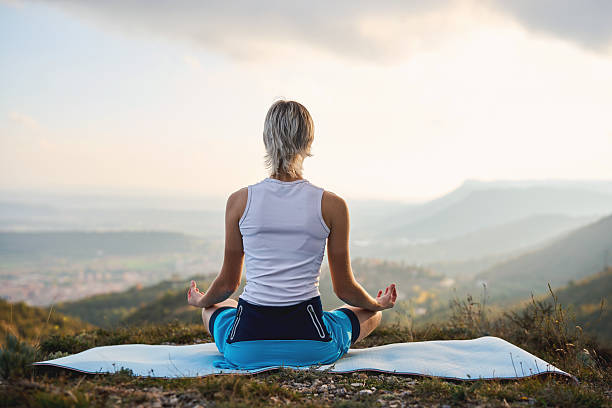 istock Young woman meditating outdoors on a mountain at sunrise 2245272721