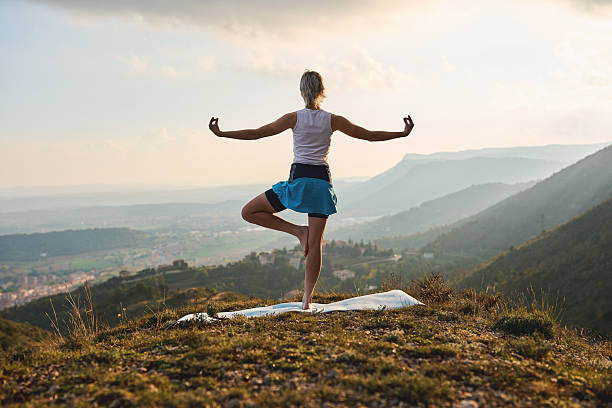 istock Woman practicing yoga balance pose on mountain at sunrise 2245272752