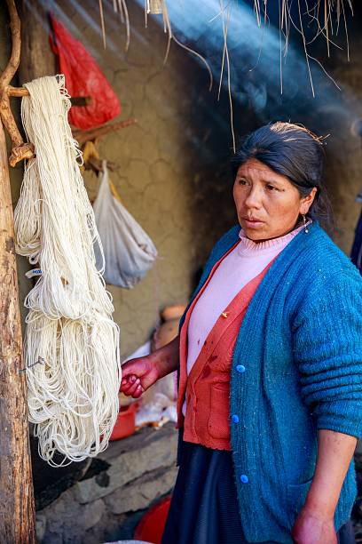 Bhaktapur, Nepal - April 20, 2016: hindu old women weaving in the street of medieval town of Bhaktapur in Nepal.