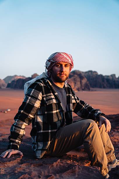 istock Man in desert at sunset with keffiyeh 2245273453