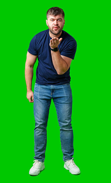 istock A man blowing a kiss while standing against a bright green backdrop in a casual outfit 2245276168