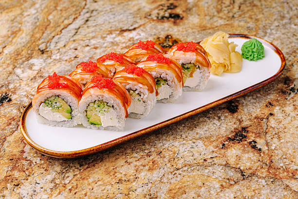 istock Fresh sushi rolls with avocado and salmon on a marble table 2245278000