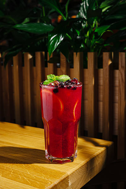 istock Refreshing crimson drink with mint and berries on wooden table 2245278271