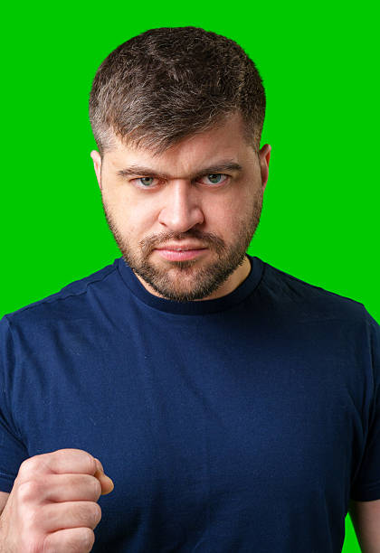 Assertive man making a fist against a bright green backdrop
