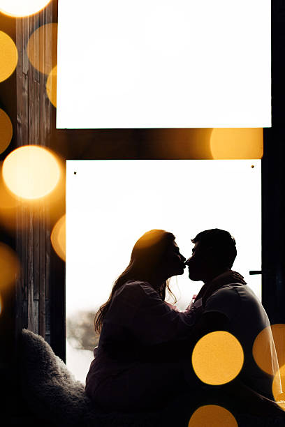 istock girl and guy sitting on windowsill and looking at each other 2245280844