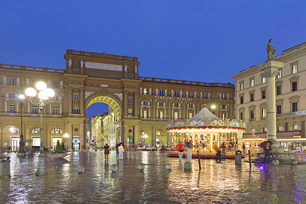 Florence, Italy - January 20, 2025: Night view of Piazza della Repubblica in Florence, Tuscany, Italy, showing the illuminated Arcone and the classic carousel. The lively historic Florentine piazza was rebuilt during the 19th century.