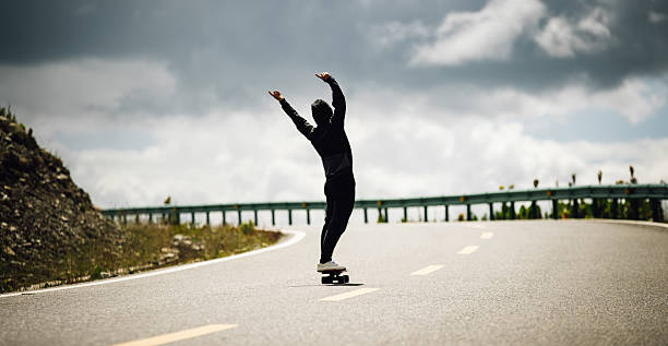 istock Skateboarder skateboarding on the mountain road 2245283405