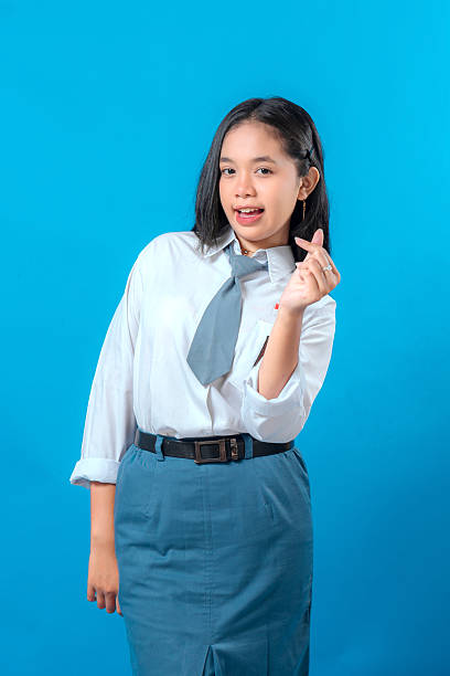 istock Cheerful Indonesian high school student smiling while making a finger heart gesture. Her bright expression and confident pose reflect friendliness, fun, and youthful charm. 2245285167