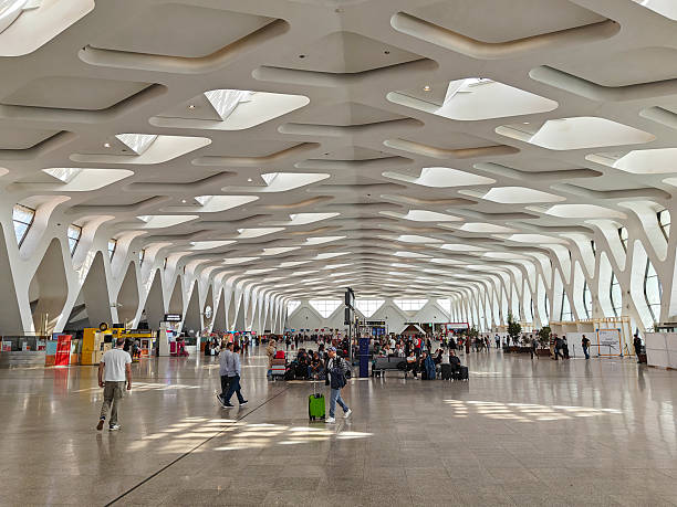 5 November 2025 Marrakesh, Morocco. ravelers inside the modern Marrakesh Menara Airport terminal in Morocco, featuring striking geometric architecture and natural light streaming through the patterned ceiling.