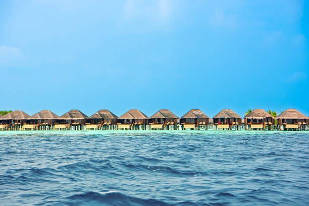 Maldives Water Villa Bungalow Overwater in idyllic turquoise beach lagoon at luxury resort hotel with wood jetty