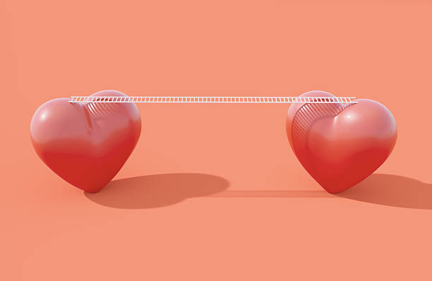 Two hearts connected by a white bridge on orange background. Love harmony and relationship difficulties concept.