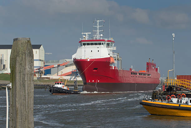 Tug boats pulling a freightship in the harbor of Harlingen Friesland. Shipping navigation in the Netherlands