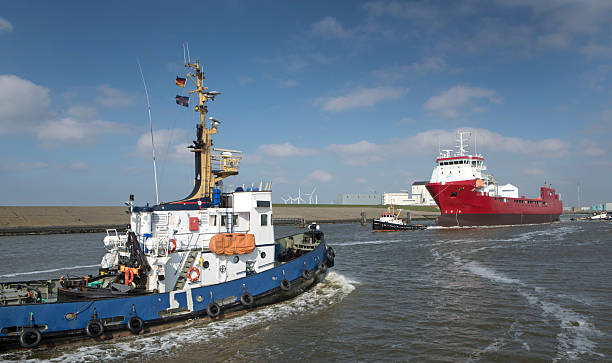 Tug boats pulling a freightship in the harbor of Harlingen Friesland. Shipping navigation in the Netherlands