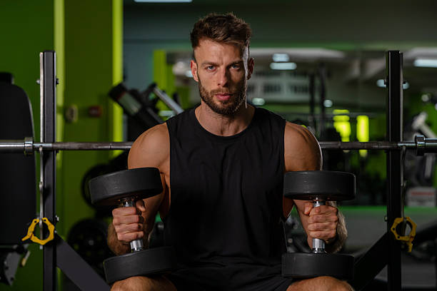 istock Strong Man with Dumbbells in Dark Gym Setting 2245290821