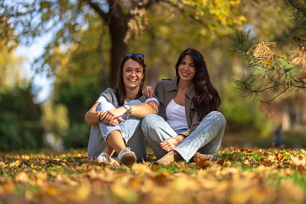 Two friends are spending time in the park, hanging out and laughing.