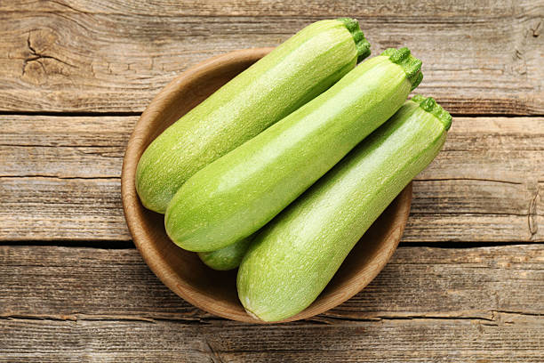 istock Fresh ripe zucchinis on wooden table, top view 2245292314