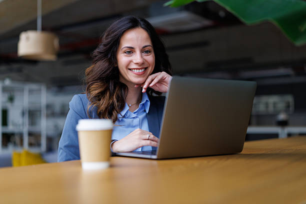 istock Confident businesswoman smiling while working with laptop 2245292442